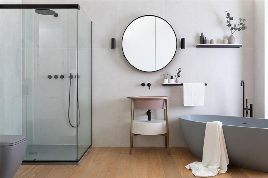 a bathroom with a bath tub and a mirror at The Cambridge in Warrane