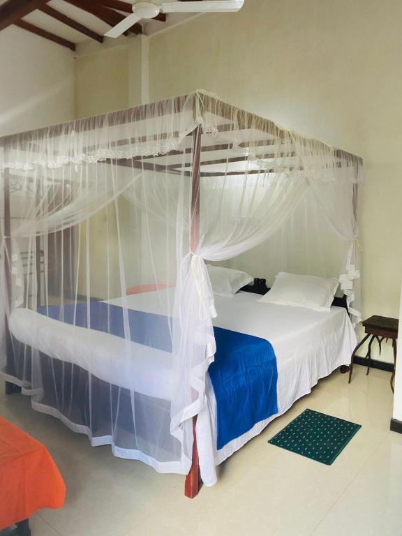 a bedroom with a bed with a canopy at Heaven Of Hikka in Hikkaduwa