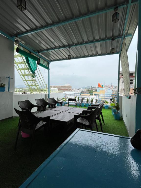Un patio con mesas y sillas en un tejado. en Turtle Hostel Udaipur- 10 mtr from Lake, en Udaipur