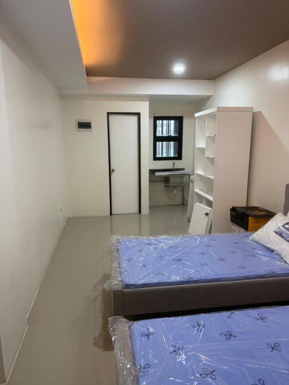 a room with two beds and a sink in it at Amp rental unit in Manila