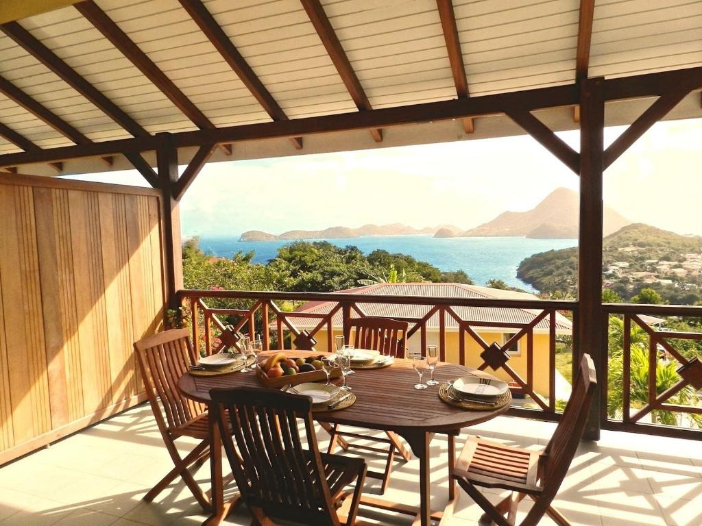una mesa en un balcón con vistas al océano en Coco D'Iles, en Terre-de-Bas