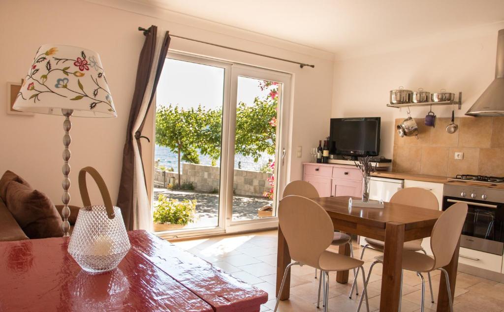 cocina y comedor con mesa y ventana en Waterfront Apartment, en Kućište