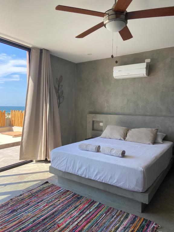 a bedroom with a bed and a ceiling fan at La Morada - Casa de playa frente al mar en Estreno in Canoas De Punta Sal
