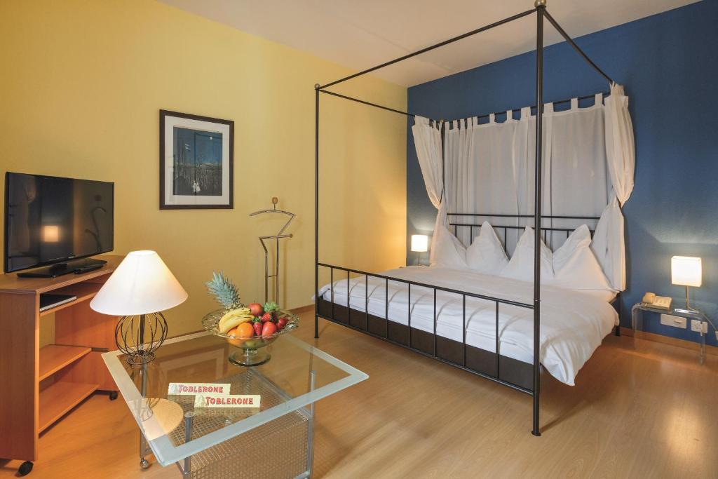 ein Schlafzimmer mit einem Himmelbett und einem Glastisch in der Unterkunft Apartments zum Löwen in Luzern