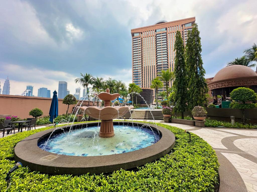 a fountain in a park in front of a building at Luxy Service Apartment at Times Square KL in Kuala Lumpur