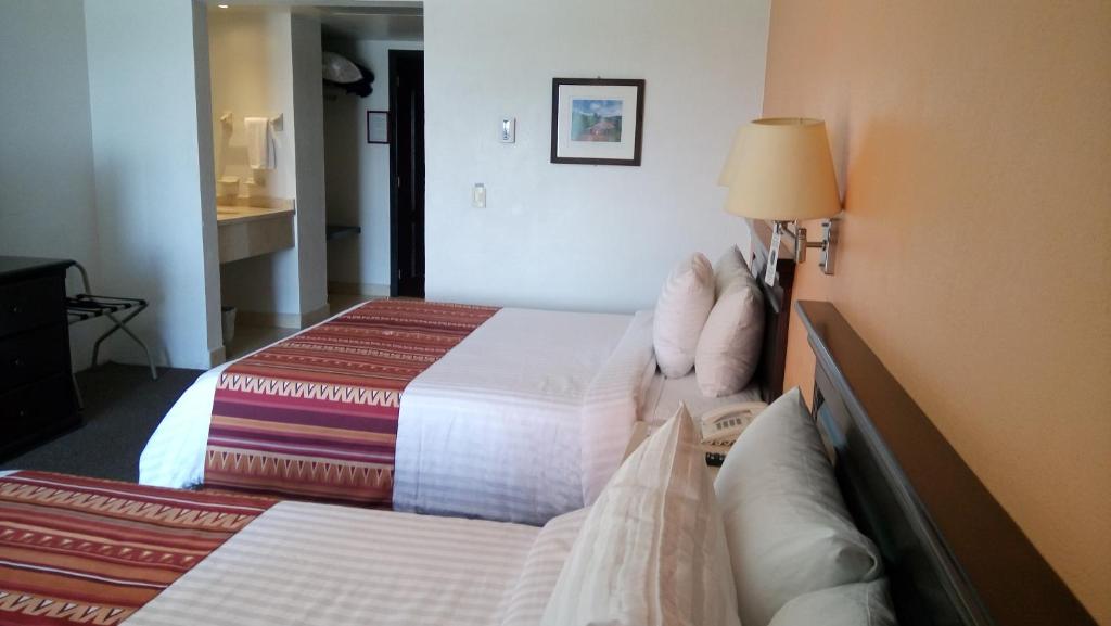 Postel nebo postele na pokoji v ubytování HG Hotel