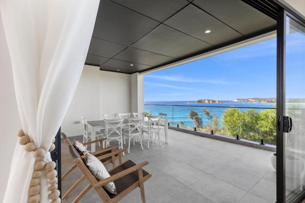 a dining room with a view of the ocean at Luma at Malua Bay in Malua Bay