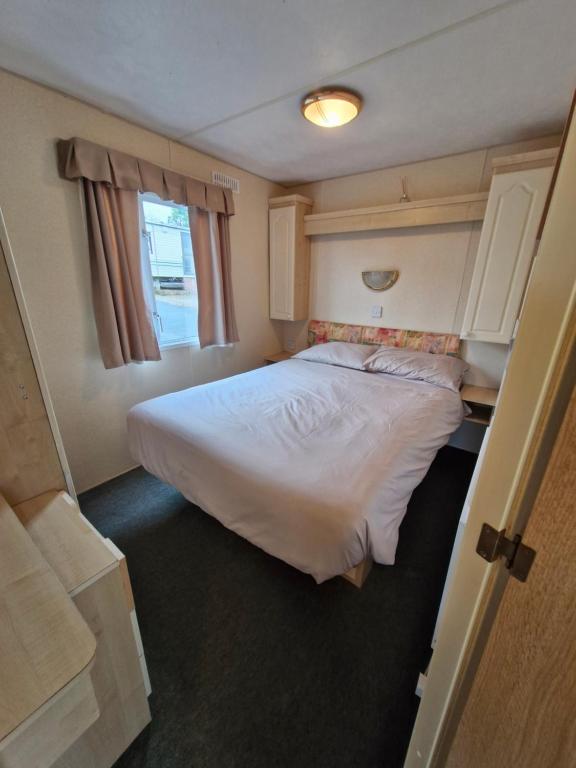a bedroom with a large white bed in a room at Caravan 26 fishguard holiday park in Fishguard