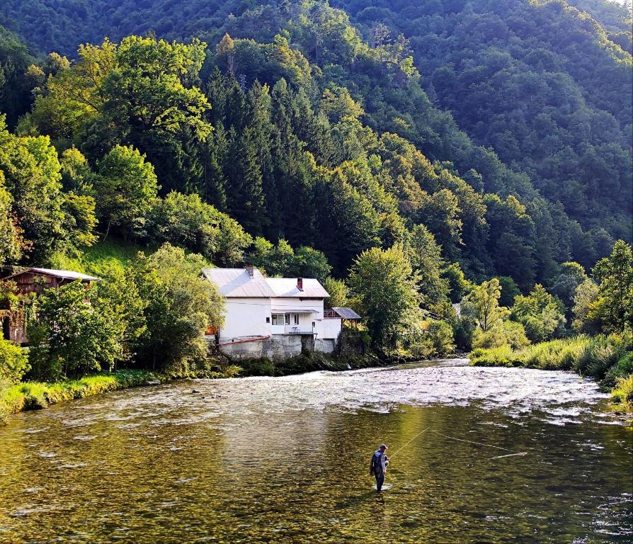 a man is standing in the water in a river at Holiday Home Mila in Spodnja Idrija