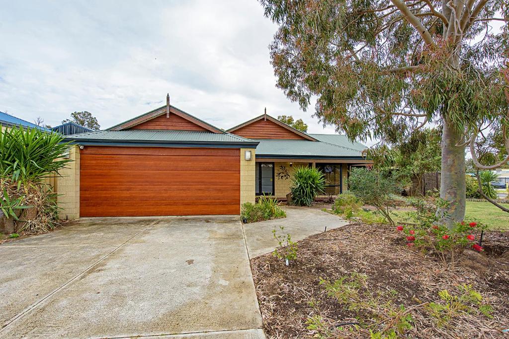 une maison avec une porte de garage en bois dans l'établissement Sky Blue Retreat Serene Family Getaway, à North Boyanup