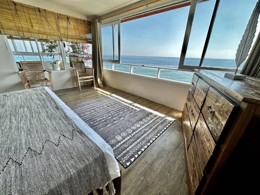 a bedroom with a bed and a view of the ocean at Beach front villa , All Mare 2 in Uluwatu