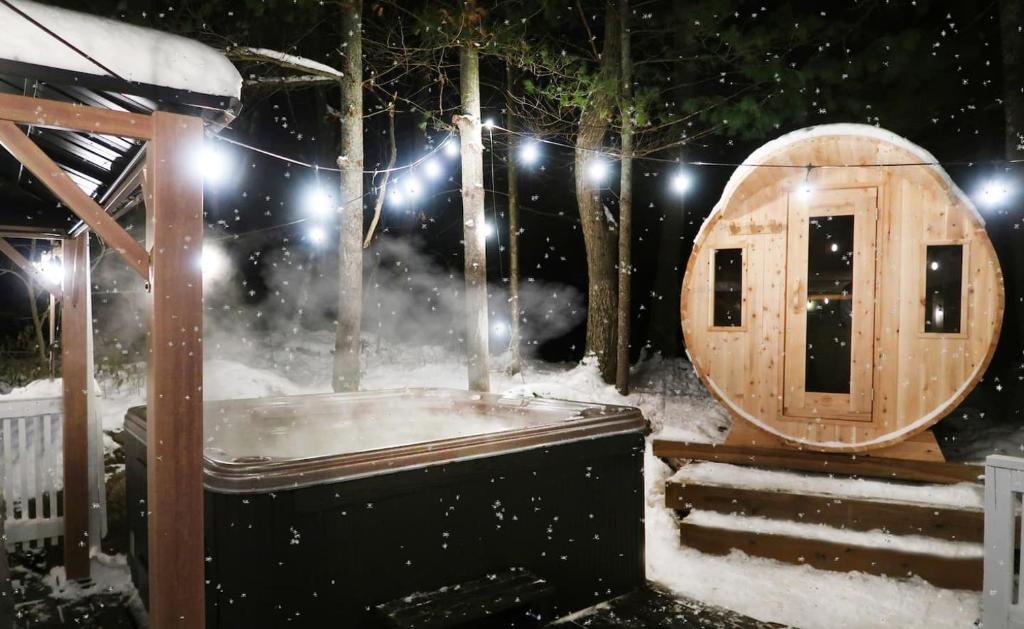 a wooden sauna in a snow covered yard at Winter Escape Waterfront Cottage Hottub&sauna! in Gravenhurst