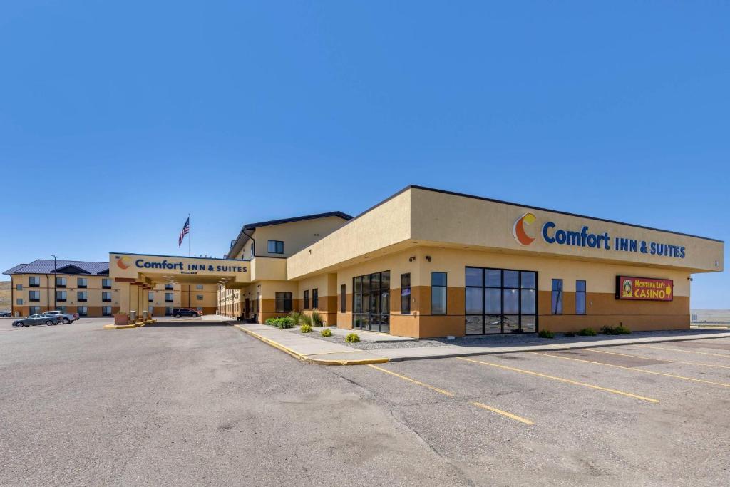 a building with a parking lot in front of it at Comfort Inn & Suites Gateway to Glacier National Park in Shelby