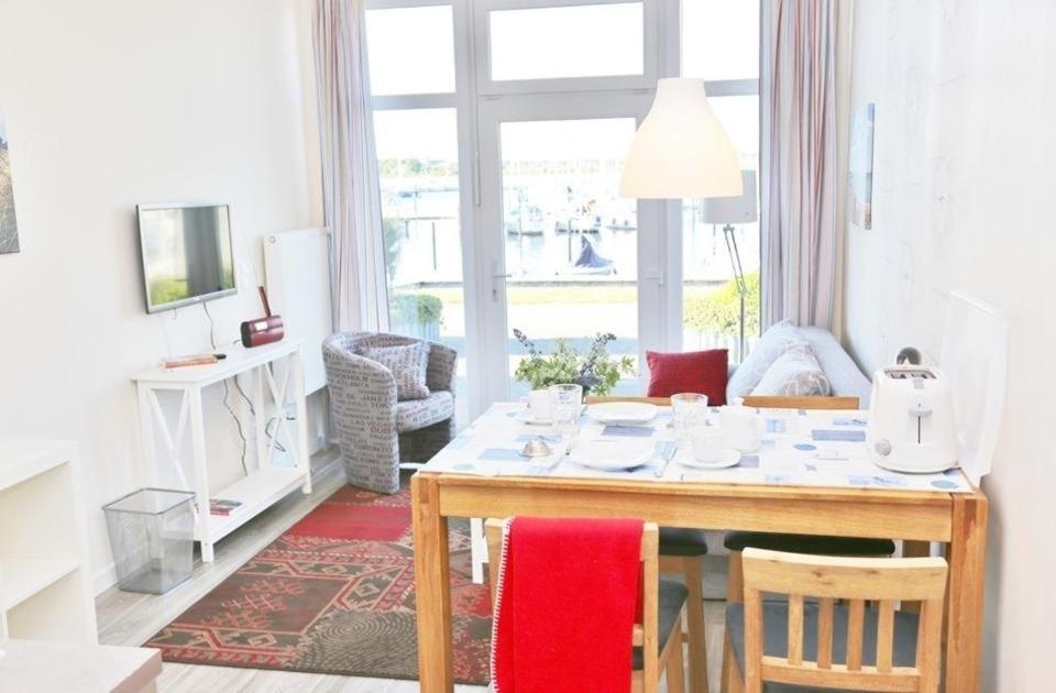 a living room with a table with chairs and a window at Am Rundsteg 5 in Burgtiefe auf Fehmarn 