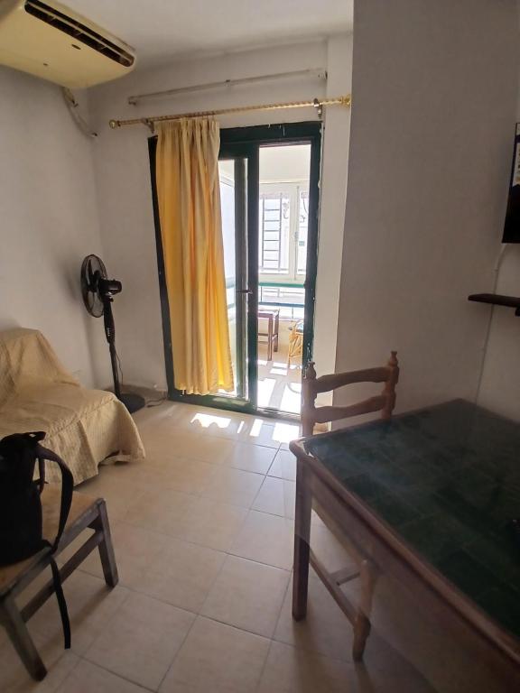 a room with a table and a bed and a window at Criss Naama bay in Sharm El Sheikh