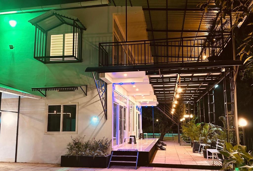 a building with a balcony with a table and chairs at Vythiri Windsor in Wayanad
