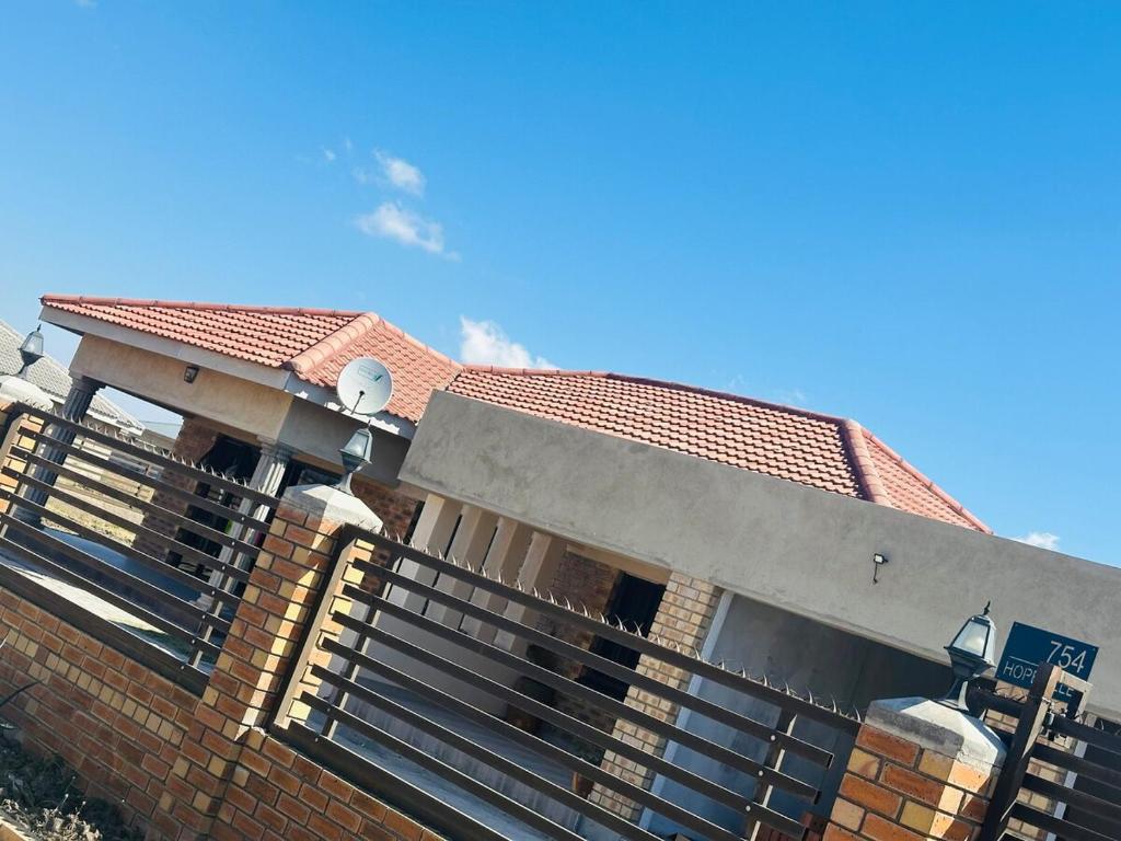 a house with a fence in front of it at Knovi Guesthouse in Bulawayo