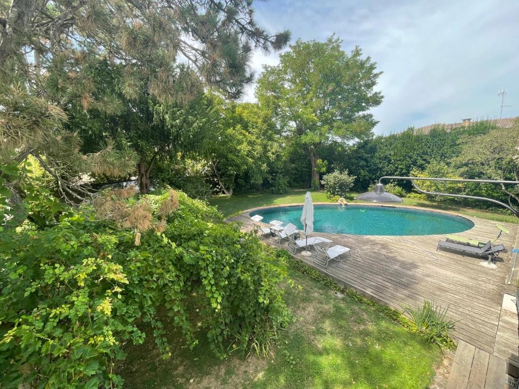 a swimming pool with a wooden deck next to at B&B Il Giardino in Melara