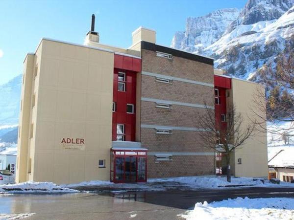 a building in front of a snow covered mountain at Adler 82 in Leukerbad