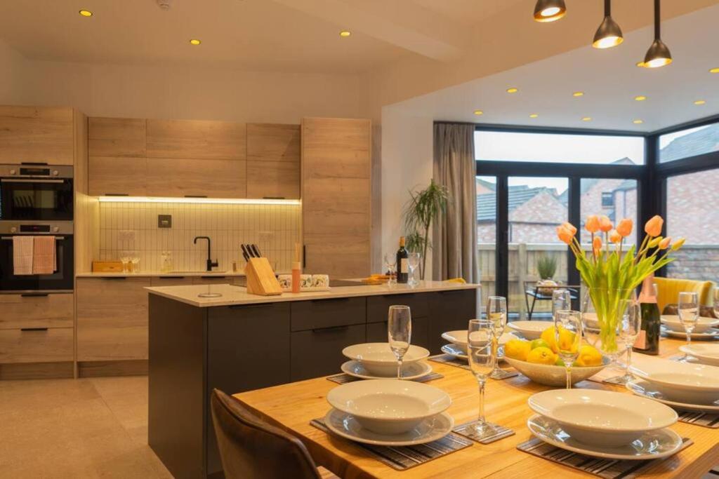 a kitchen with a table with plates and glasses on it at Escape 2 Unwind At The Parade, Accommodates 10 in York