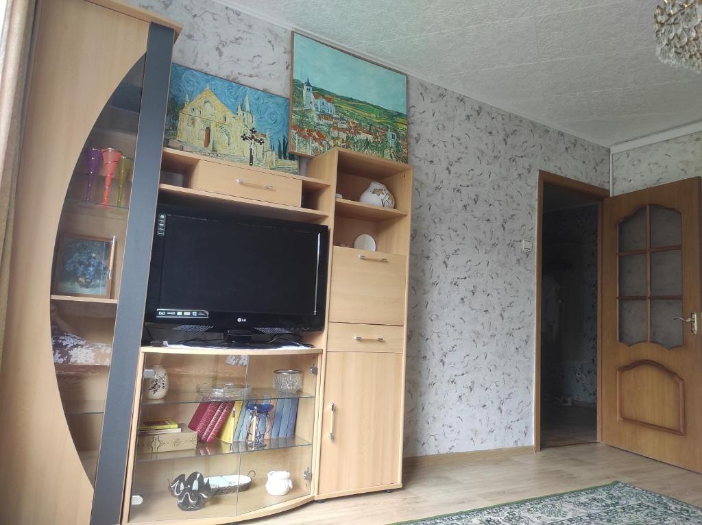 a tv in a book shelf in a room at Flowery apartment in Jūrmala