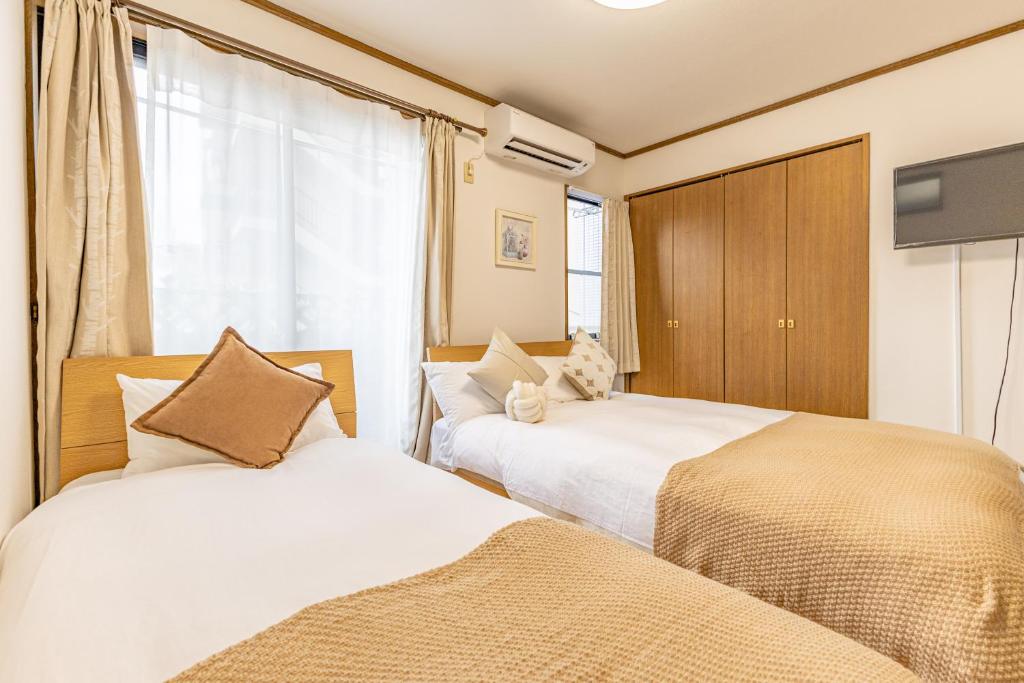 a bedroom with two beds and a tv in it at TokyoTokyo in Wada