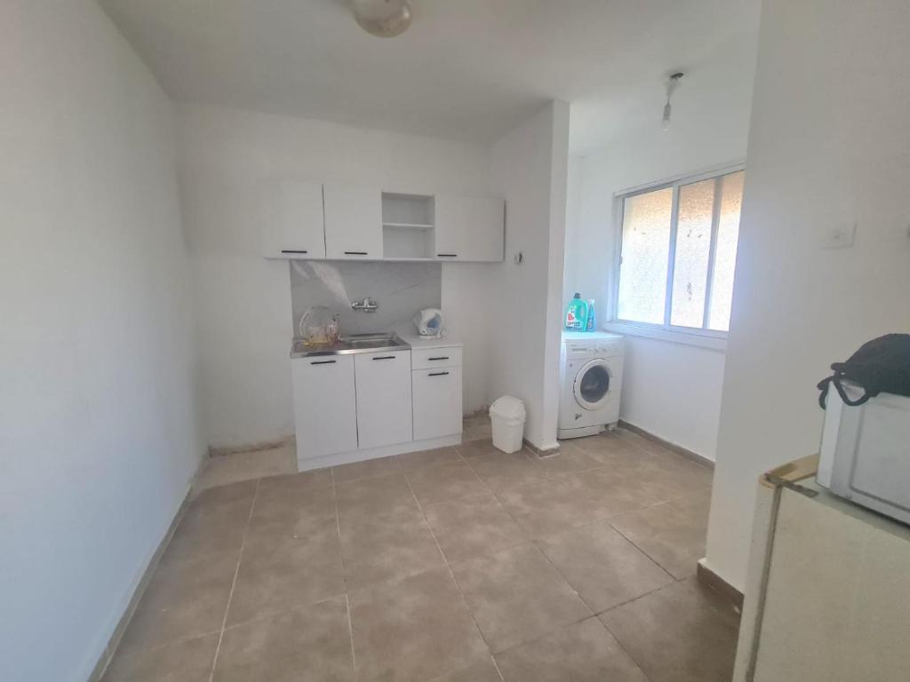 een witte keuken met een wastafel en een wasmachine bij Family vacation in Tiberias