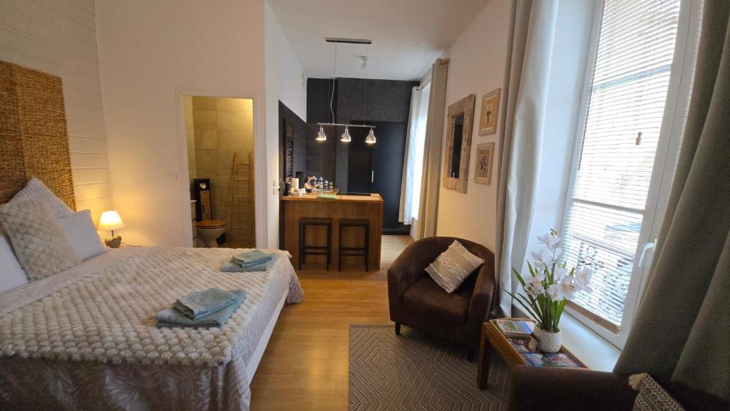 une chambre avec un lit et une chaise dans une pièce dans l'établissement Kalu Studio 8 - Studio cosy Centre médiéval Sarlat, à Sarlat-la-Canéda