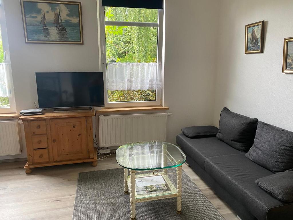 a living room with a couch and a flat screen tv at Ferienwohnung -Bernie EG Sandhorst in Aurich