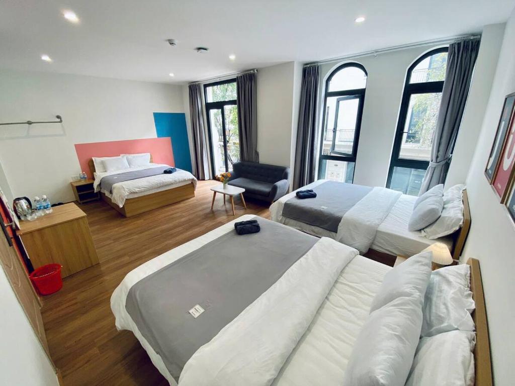 a hotel room with two beds and a couch at Lustay Triple Room- KD518- 3 giường in Ðình Loan