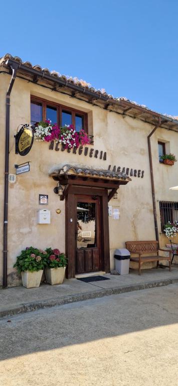 a building with pots of flowers in front of it at Albergue Laganares - Exclusivo para peregrinos in San Nicolás del Real Camino