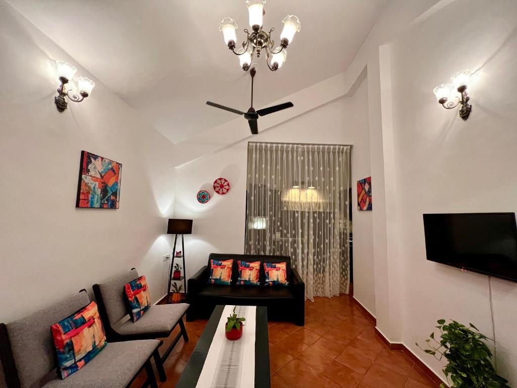 a living room with a couch and a table and a television at La Bella By The Beach Goa in Goa