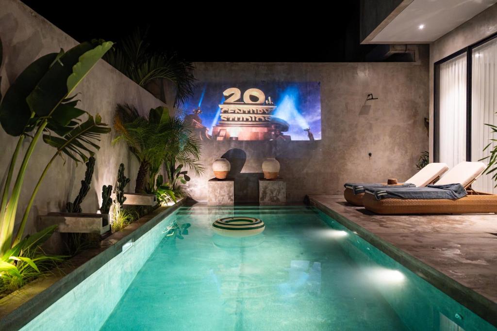 a swimming pool in a room with a table and chairs at Balenji Villa by BaliSuperHost in Munggu