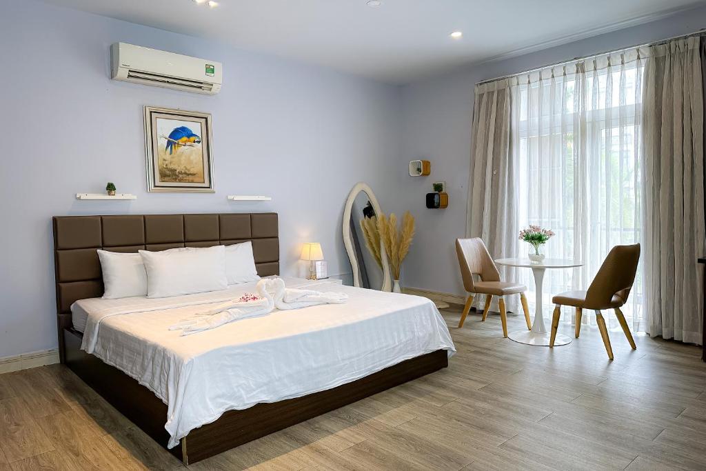a bedroom with a bed and a table and chairs at Eva Adam Hotel in Ho Chi Minh City