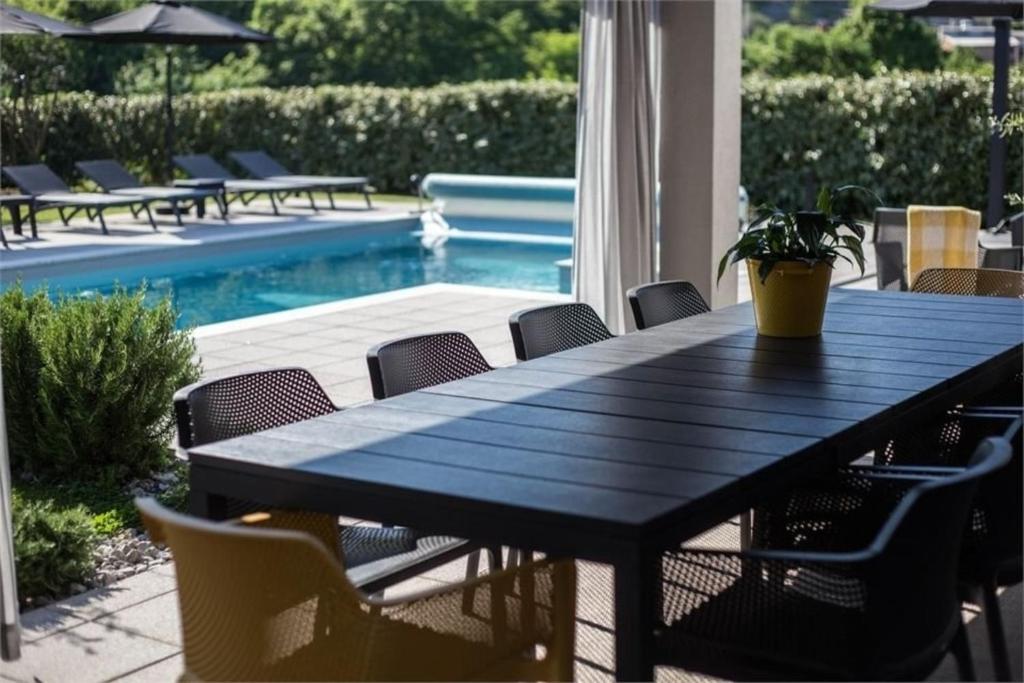 マトゥリにあるLuxury Villa Susanjの黒いテーブル(椅子付)、スイミングプール