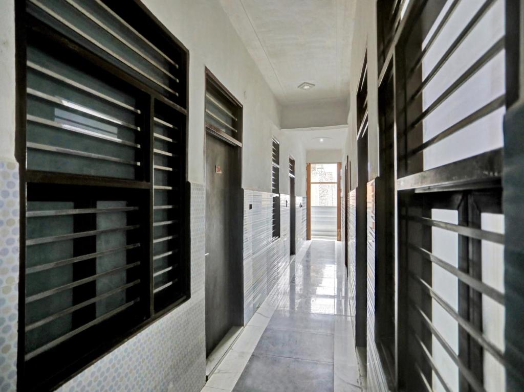 Un pasillo con paredes de azulejos blancos y negros. en Hotel O Hotel Valentine's, en Rohtak