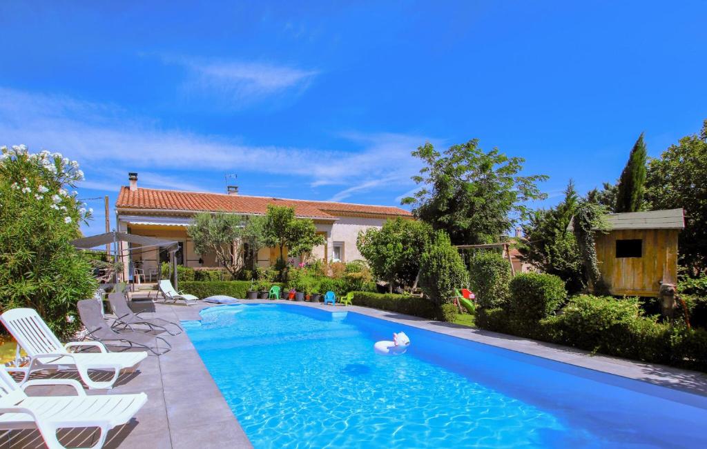 a swimming pool with chairs and a swan in the water at Cozy Home In Bedarrides in Bédarrides