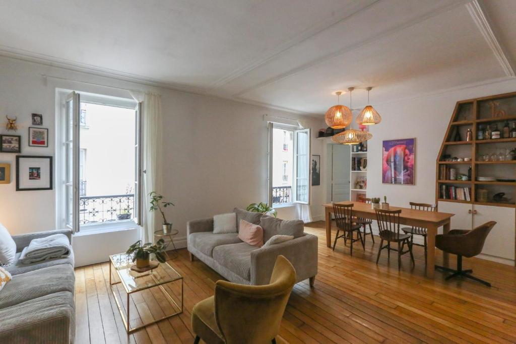 un salon avec un canapé et une table dans l'établissement Spacious apartment near the Villette, à Paris