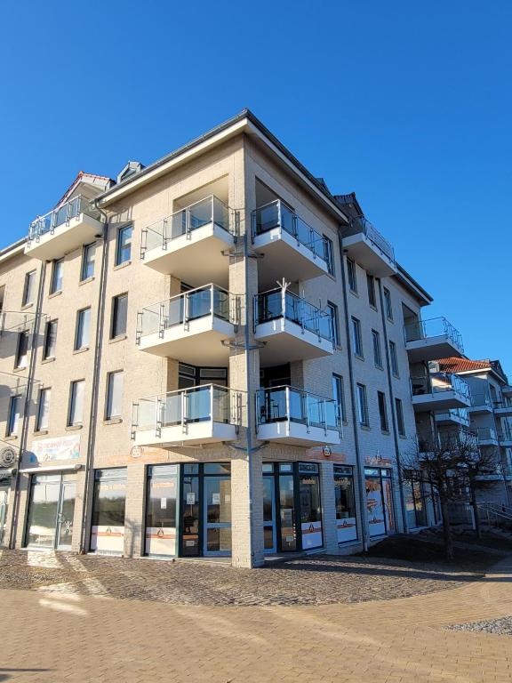 Un edificio alto con balcones a los lados. en Inseloase, en Fehmarn