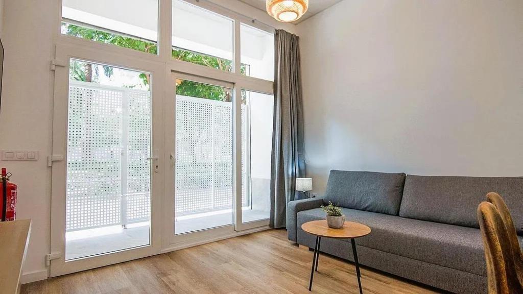 a living room with a couch and a large window at LUXURY APARTMENT SCIENCES CITY Valencia B in Valencia