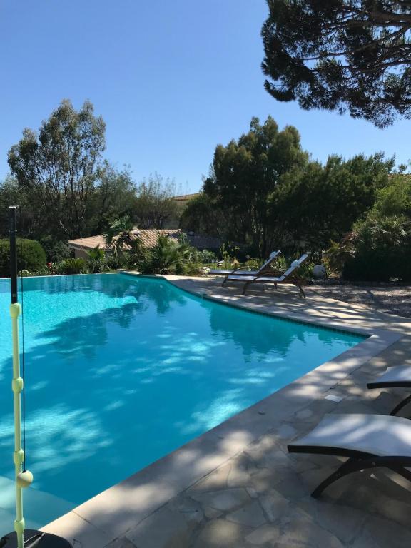 a swimming pool with chairs and blue water at Le lagon Bleu suite 5 étoiles villa Côté Cœur in Les Issambres