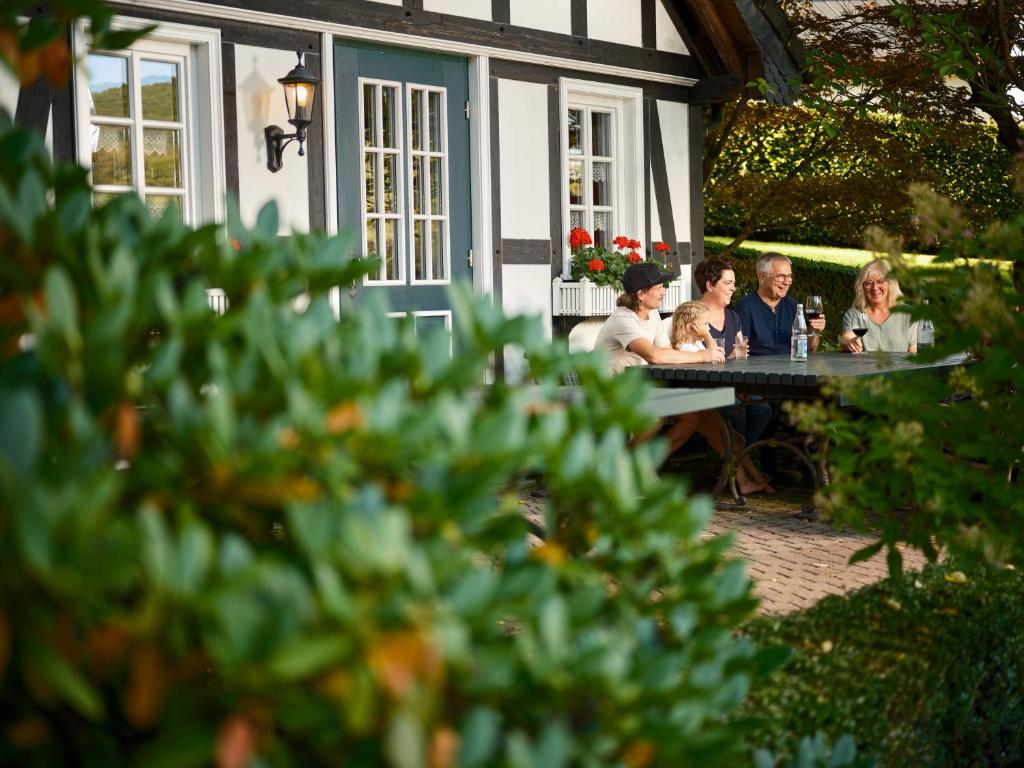 a group of people sitting at a table outside a house at Villa Klassika Jürgens in Attendorn