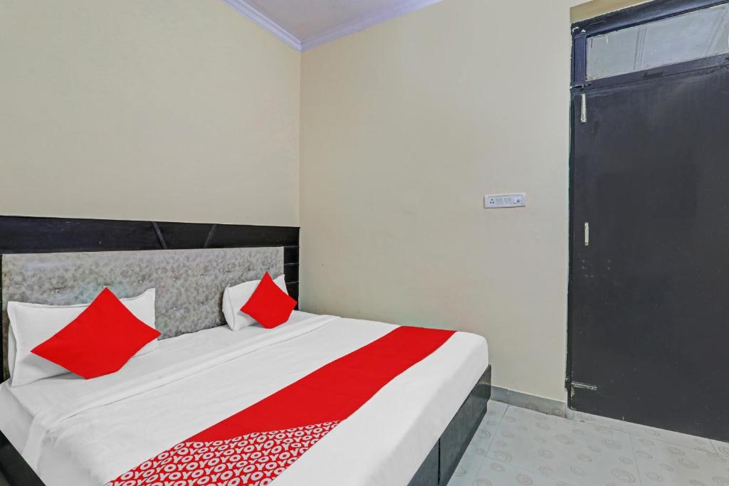 a bedroom with a bed with red pillows at Hotel O Four Square in Lucknow