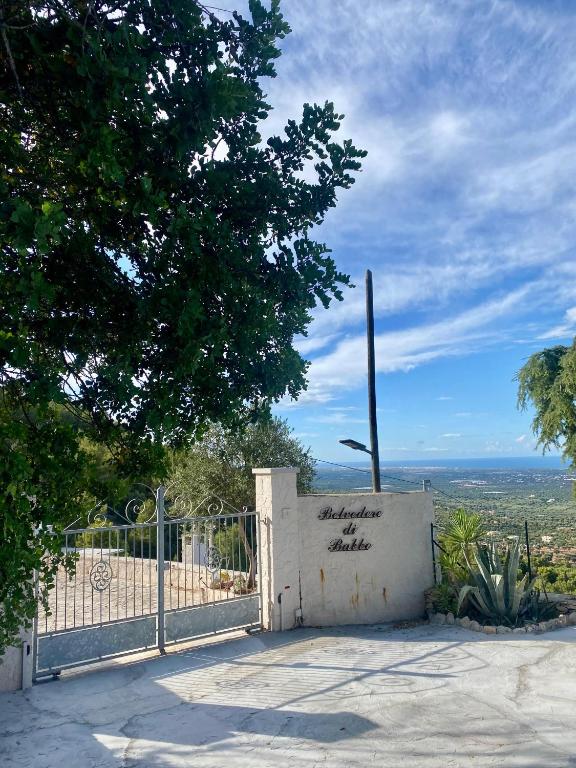a gate with a sign on it next to a fence at Il Belvedere di Babbo in Fasano