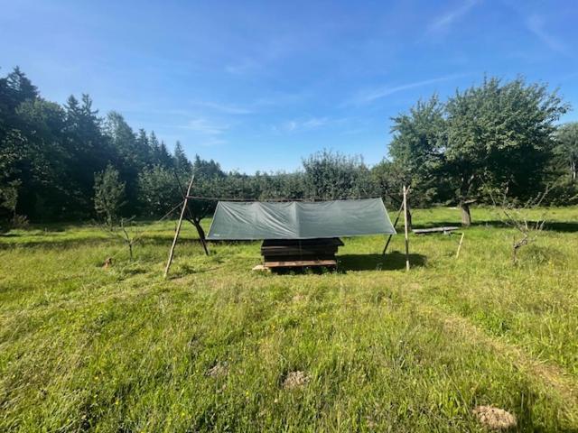 eine grüne Plane auf einem Feld in der Unterkunft Wiesenbett unterm Nachthimmel in Regen