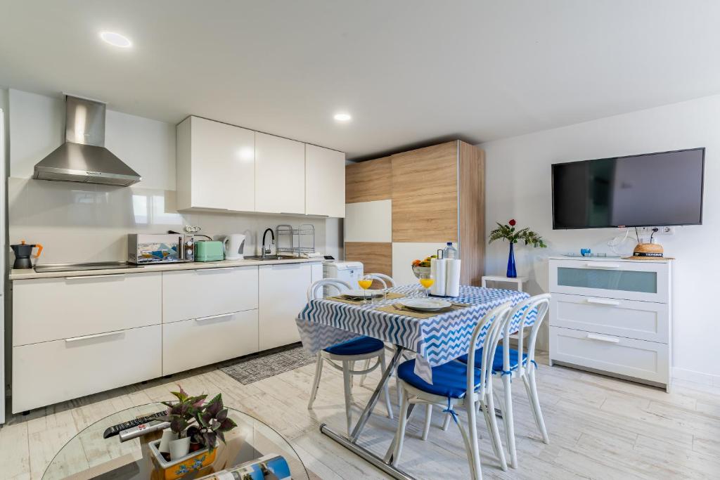 une cuisine avec une table avec des chaises et une télévision dans l'établissement Down Floor Studio in Centre City Puerto de la Cruz, à Puerto de la Cruz