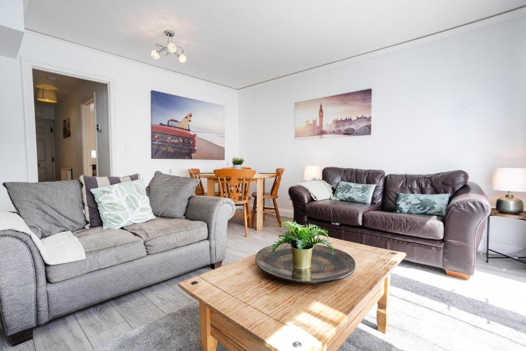 een woonkamer met twee banken en een salontafel bij Courtsknap Contractors Sleeps 9 Free Parking WiFi in Swindon
