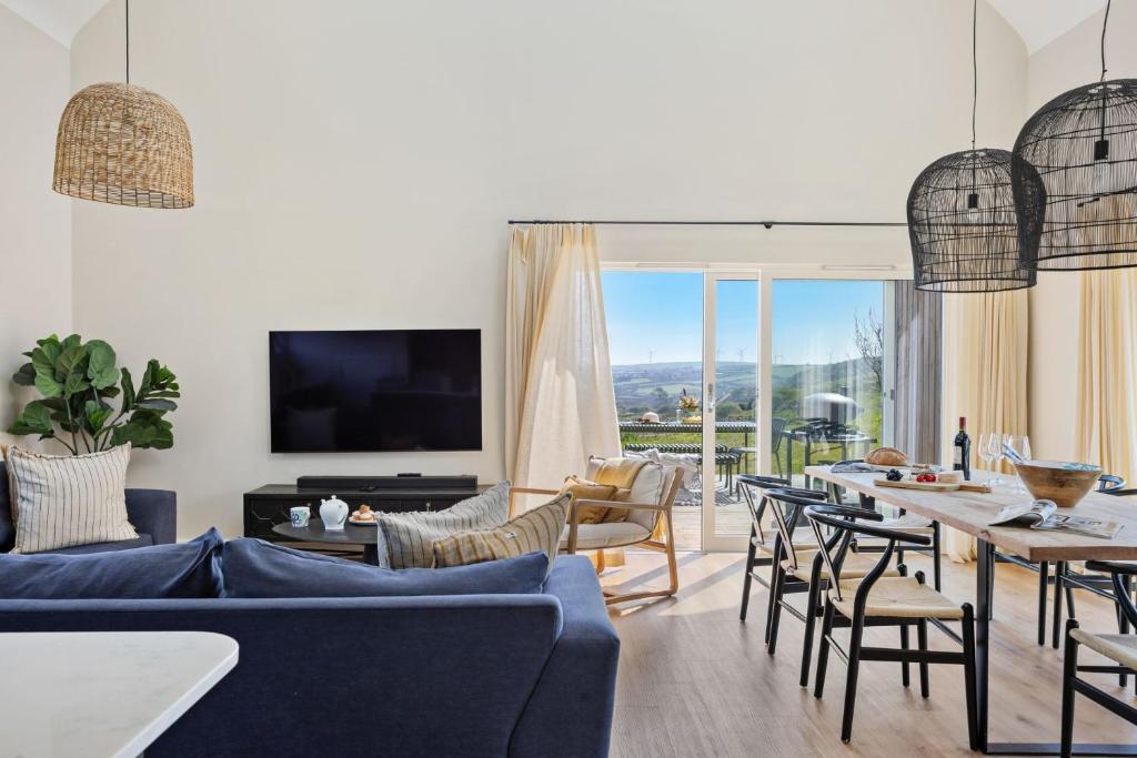 a living room with a blue couch and chairs at No 3 The Vista, Willingcott, Woolacombe in Woolacombe