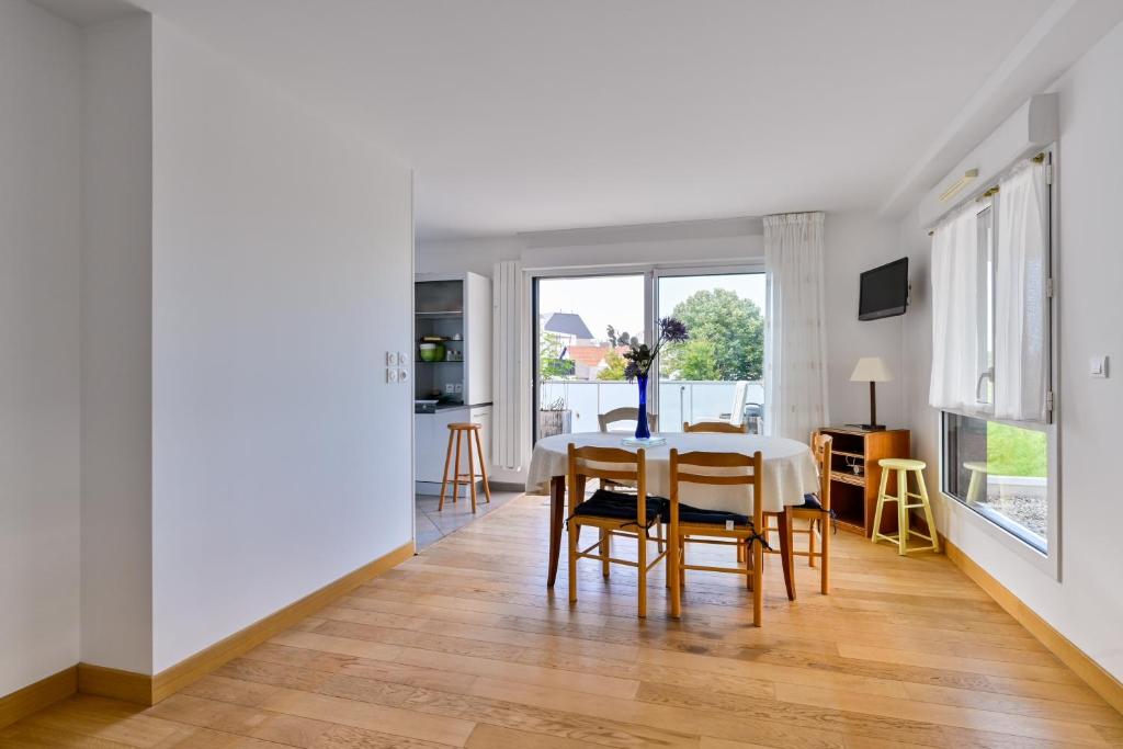 a dining room and living room with a table and chairs at Le Rev - à 900m de la plage in La Baule