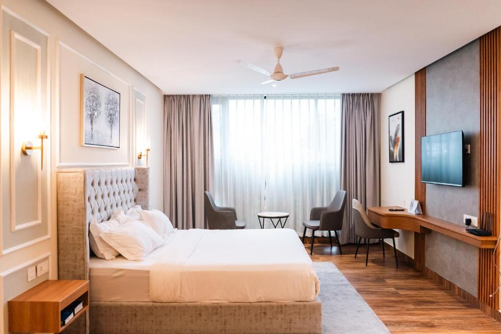a hotel room with a bed and a desk at Milestone Suites by Robinson Properties in Trivandrum
